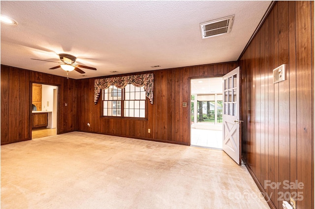1304 5th Street Cir NW, Hickory, NC 28601 - spare room with wood walls, a ceiling fan, light colored carpet, a textured ceiling, and baseboards