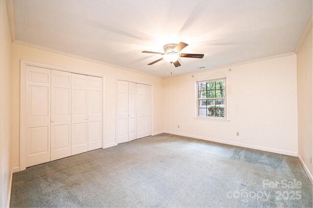 1304 5th Street Cir NW, Hickory, NC 28601 - unfurnished bedroom featuring two closets, carpet floors, ornamental molding, baseboards, and a ceiling fan