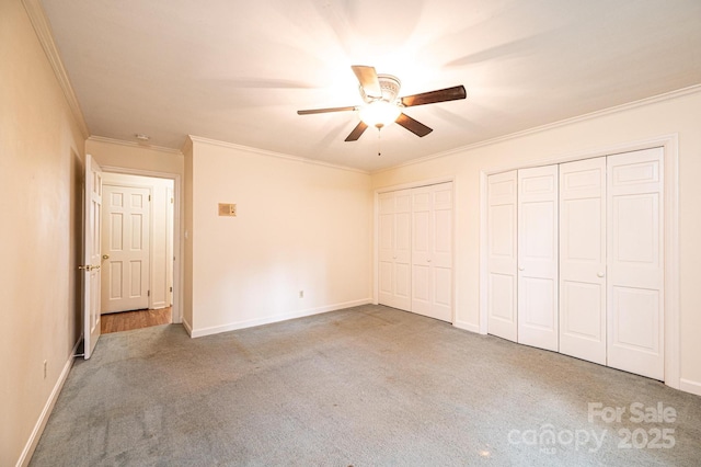 1304 5th Street Cir NW, Hickory, NC 28601 - unfurnished bedroom featuring multiple closets, carpet flooring, crown molding, baseboards, and ceiling fan