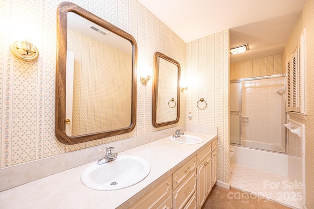 1304 5th Street Cir NW, Hickory, NC 28601 - full bathroom featuring wallpapered walls, double vanity, enclosed tub / shower combo, toilet, and tile patterned floors
