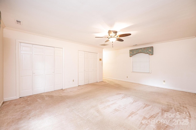 1304 5th Street Cir NW, Hickory, NC 28601 - unfurnished bedroom with crown molding, two closets, carpet, baseboards, and a ceiling fan