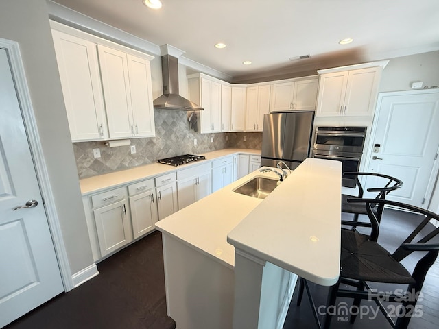 114 Mint Ave Unit A, Mooresville, NC 28117 - kitchen with wall chimney exhaust hood, appliances with stainless steel finishes, white cabinets, a kitchen bar, and a kitchen island with sink