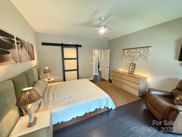 114 Mint Ave Unit A, Mooresville, NC 28117 - bedroom with a barn door, dark wood-style floors, and a ceiling fan