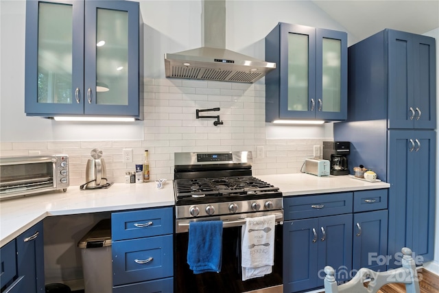 111 Altamahaw Ave, Black Mountain, NC 28711 - kitchen featuring stainless steel gas range oven, wall chimney range hood, blue cabinetry, backsplash, and glass insert cabinets
