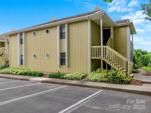110 Heywood Rd Unit 17C, Arden, NC 28704 - view of property exterior with a chimney, uncovered parking, and stairs