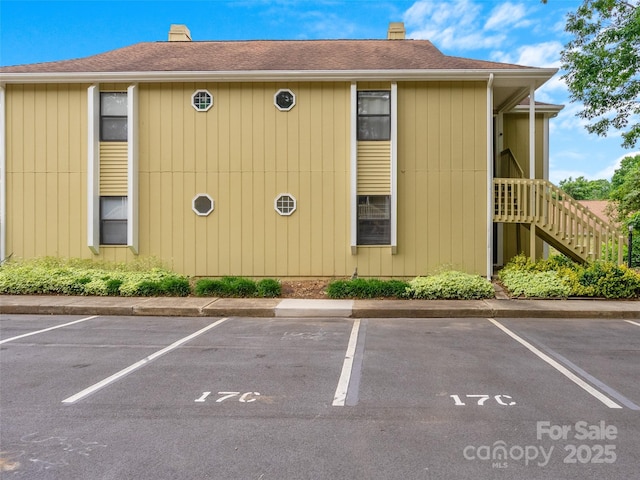 110 Heywood Rd Unit 17C, Arden, NC 28704 - view of home's exterior featuring a chimney, uncovered parking, and stairway