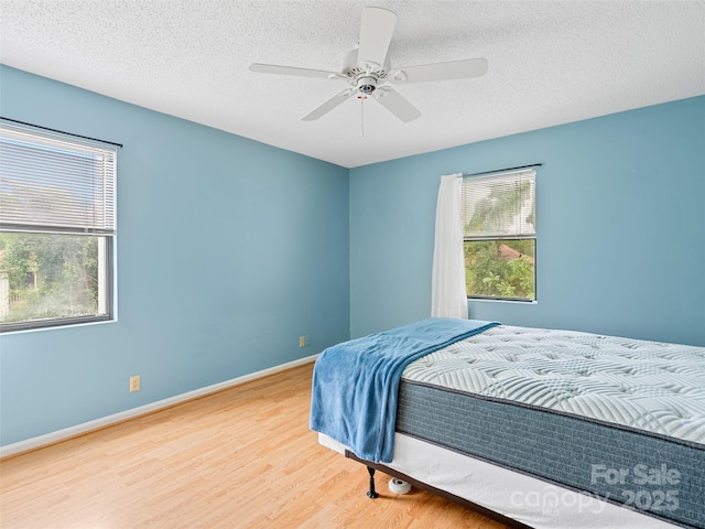 110 Heywood Rd Unit 17C, Arden, NC 28704 - bedroom featuring wood finished floors, a textured ceiling, ceiling fan, and baseboards