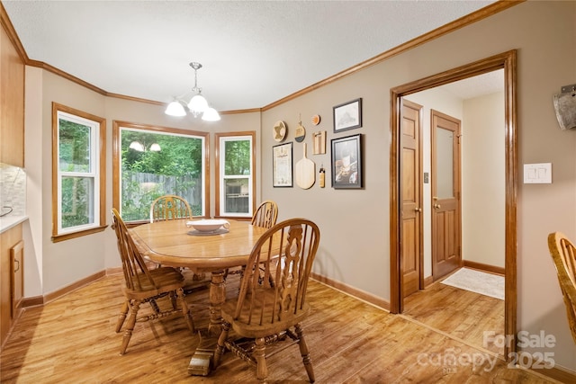 4848 Spicewood Dr, Charlotte, NC 28227 - dining room with light wood-type flooring, a chandelier, baseboards, ornamental molding, and a textured ceiling