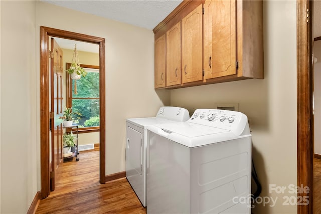 4848 Spicewood Dr, Charlotte, NC 28227 - laundry area featuring cabinet space, washing machine and clothes dryer, light wood finished floors, and baseboards