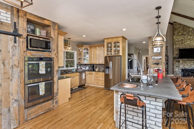 28 Mountain Vista Dr Unit 1 & 2, Asheville, NC 28804 - kitchen featuring stainless steel appliances, light brown cabinetry, a stone fireplace, light wood finished floors, and open shelves