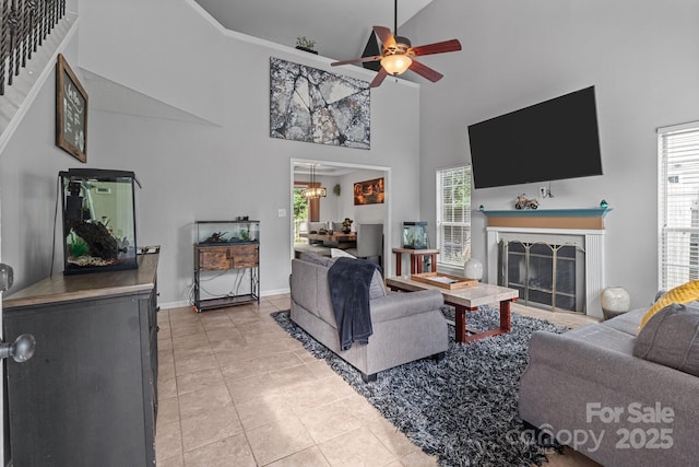 8906 Pickering Grove Ln, Charlotte, NC 28216 - living room featuring a high ceiling, light tile patterned floors, a fireplace, ceiling fan, and stairs