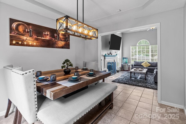8906 Pickering Grove Ln, Charlotte, NC 28216 - dining room featuring light tile patterned flooring and a fireplace