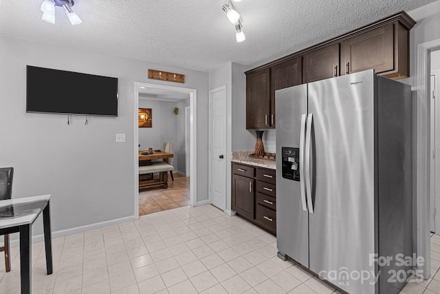 8906 Pickering Grove Ln, Charlotte, NC 28216 - kitchen with stainless steel refrigerator with ice dispenser, dark brown cabinetry, light stone countertops, a textured ceiling, and light tile patterned floors