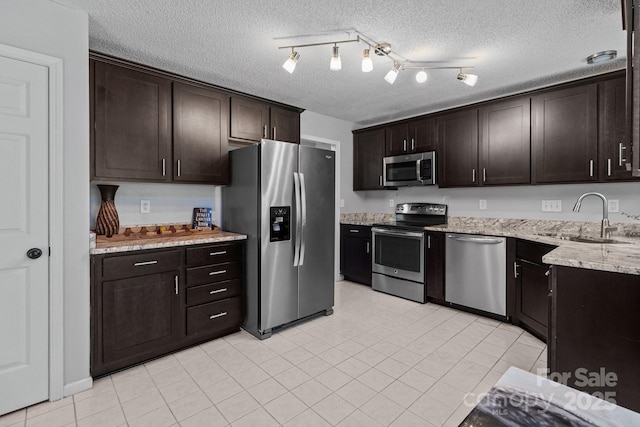 8906 Pickering Grove Ln, Charlotte, NC 28216 - kitchen with stainless steel appliances, dark brown cabinets, a textured ceiling, light stone countertops, and light tile patterned floors