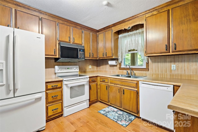 7050 W US-70 Hwy, Old Fort, NC 28762 - kitchen featuring white appliances, a sink, light countertops, a textured ceiling, and brown cabinets
