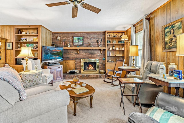 7050 W US-70 Hwy, Old Fort, NC 28762 - living room featuring wood walls, carpet floors, a ceiling fan, a fireplace, and built in shelves
