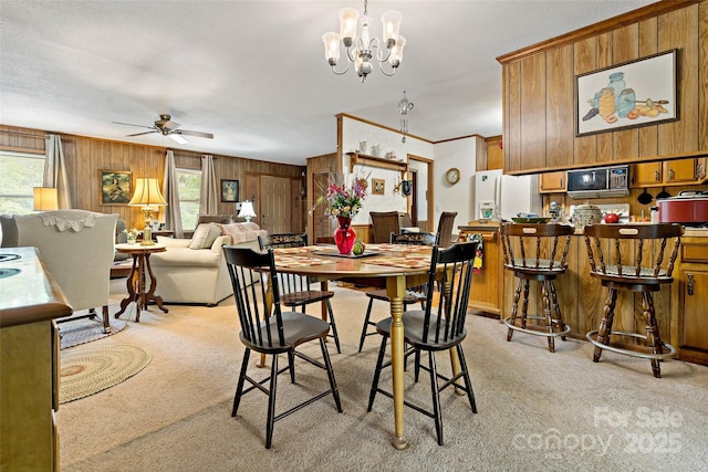 7050 W US-70 Hwy, Old Fort, NC 28762 - dining room featuring light carpet, wood walls, a ceiling fan, a chandelier, and ornamental molding