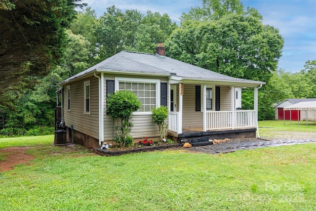 1036 20th St NE, Hickory, NC 28601 - view of front facade featuring covered porch, a chimney, a front lawn, and central AC