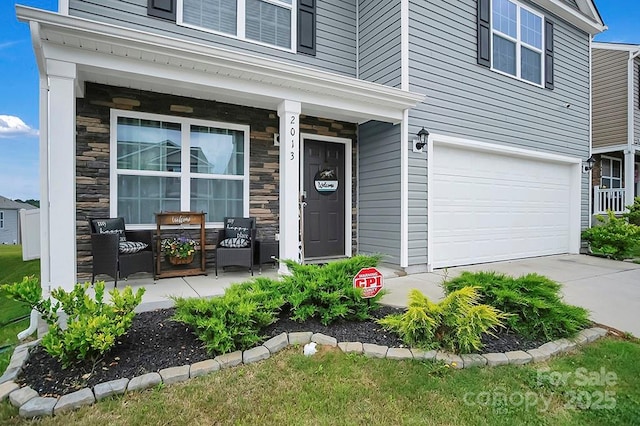 2013 Eastway Dr, Dallas, NC 28034 - view of exterior entry with stone siding, a garage, covered porch, and driveway