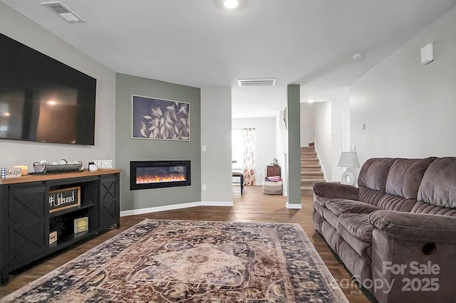 2013 Eastway Dr, Dallas, NC 28034 - living area featuring dark wood-style flooring, a glass covered fireplace, baseboards, and stairs