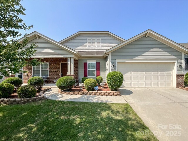 1228 Tranquil Falls Ln, Matthews, NC 28104 - view of front of house featuring brick siding, a garage, driveway, and a front lawn