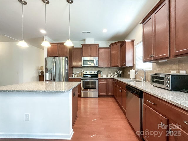 1228 Tranquil Falls Ln, Matthews, NC 28104 - kitchen with stainless steel appliances, a sink, a kitchen island, tasteful backsplash, and pendant lighting
