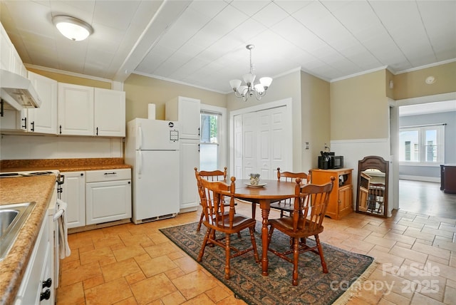435 16th St, Cramerton, NC 28032 - dining room featuring crown molding, a chandelier, healthy amount of natural light, and stone tile flooring