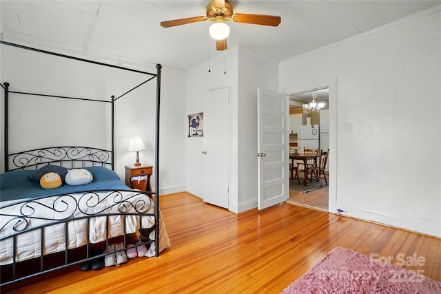 435 16th St, Cramerton, NC 28032 - bedroom featuring light wood-style flooring, a chandelier, freestanding refrigerator, ornamental molding, and a ceiling fan