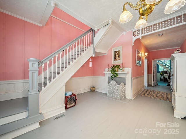 408 S Ellis St, Salisbury, NC 28144 - stairs featuring wood finished floors, a decorative wall, wainscoting, and ornamental molding