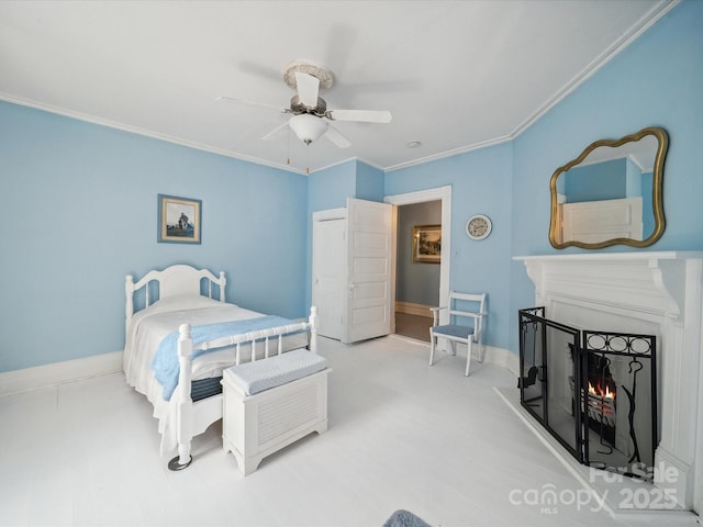408 S Ellis St, Salisbury, NC 28144 - bedroom with ornamental molding, a warm lit fireplace, a ceiling fan, and a closet