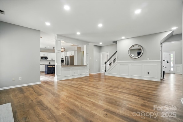 1522 Napa St NW, Concord, NC 28027 - unfurnished living room with light wood finished floors, stairs, and recessed lighting