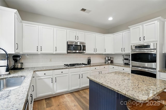 1522 Napa St NW, Concord, NC 28027 - kitchen with appliances with stainless steel finishes, white cabinetry, backsplash, and recessed lighting