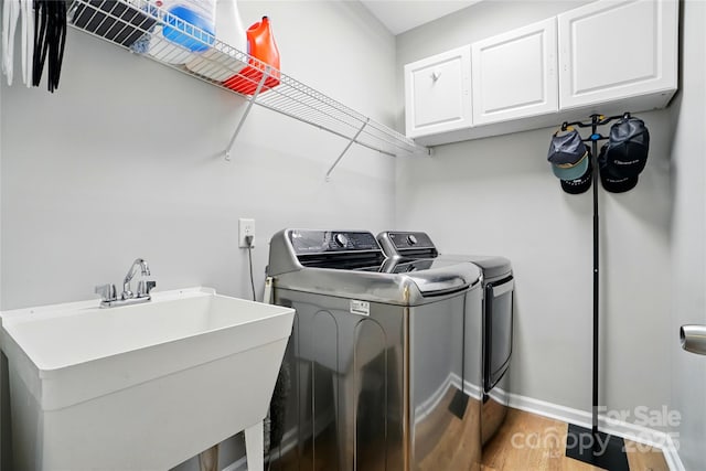 1522 Napa St NW, Concord, NC 28027 - laundry room with cabinet space, washer and clothes dryer, light wood-style flooring, and baseboards