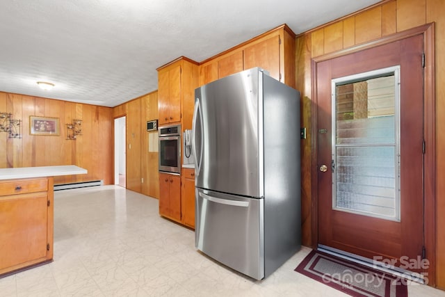 518 W School St, Maiden, NC 28650 - kitchen with stainless steel appliances, a baseboard radiator, brown cabinets, light countertops, and wood walls