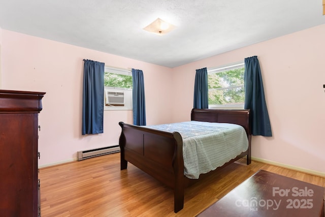 518 W School St, Maiden, NC 28650 - bedroom with baseboard heating, multiple windows, light wood-type flooring, and cooling unit