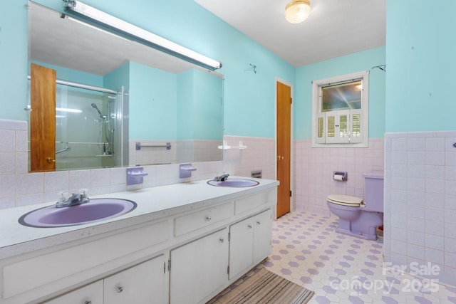 518 W School St, Maiden, NC 28650 - bathroom with tile walls, wainscoting, a stall shower, double vanity, and toilet