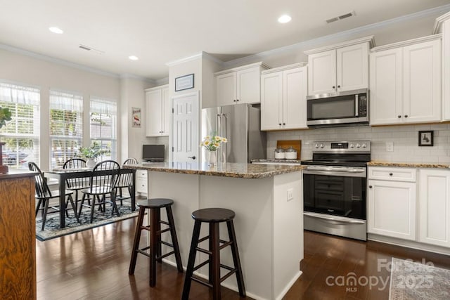 2066 Vermount Way, Indian Land, SC 29707 - kitchen featuring appliances with stainless steel finishes, a kitchen island, dark wood finished floors, white cabinets, and crown molding