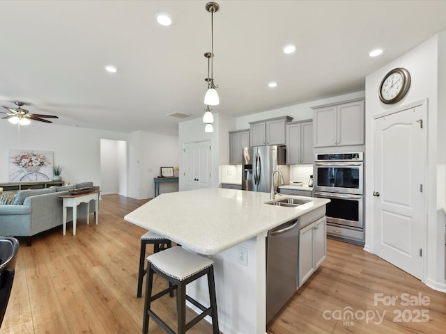 200 Sweet Briar Dr, Fort Mill, SC 29707 - kitchen featuring appliances with stainless steel finishes, a sink, gray cabinets, open floor plan, and a kitchen island with sink