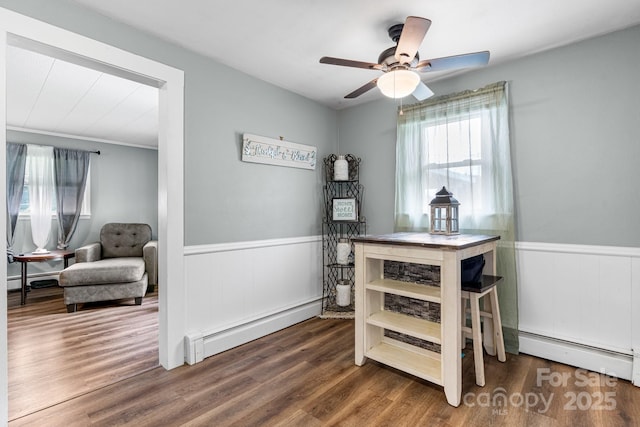 1266 18th St NE, Hickory, NC 28601 - dining area featuring baseboard heating, healthy amount of natural light, a wainscoted wall, wood finished floors, and a ceiling fan