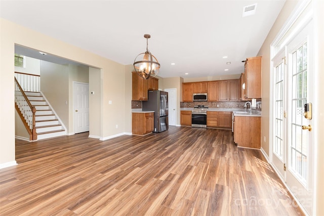 13305 Mallard Landing Rd, Charlotte, NC 28278 - kitchen with stainless steel appliances, light countertops, decorative backsplash, light wood-style floors, and a chandelier