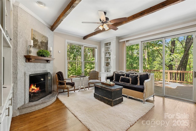 310 Southwood Ln, Columbus, NC 28722 - living area with a fireplace, a ceiling fan, beam ceiling, light wood finished floors, and crown molding