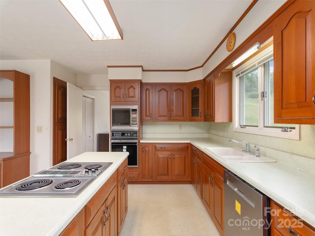 202 Terrell Rd, Clyde, NC 28721 - kitchen with stainless steel appliances, a sink, brown cabinetry, light countertops, and glass insert cabinets