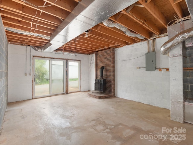 202 Terrell Rd, Clyde, NC 28721 - below grade area with electric panel, a wood stove, and concrete block wall