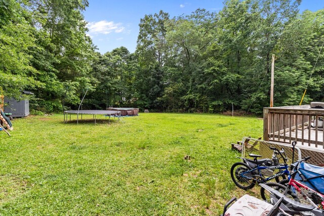2146 Marwood Ln, Albemarle, NC 28001 - view of grassy yard with a trampoline, a deck, and a storage unit