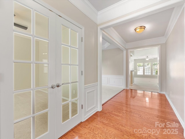 8603 Robinson Meadow Ct, Charlotte, NC 28277 - hall with french doors, wood finished floors, crown molding, a wainscoted wall, and a decorative wall