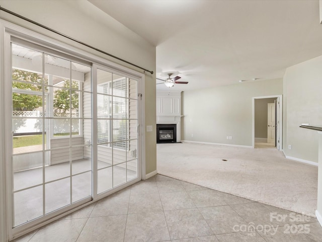 8603 Robinson Meadow Ct, Charlotte, NC 28277 - empty room with light colored carpet, a ceiling fan, light tile patterned flooring, and a glass covered fireplace