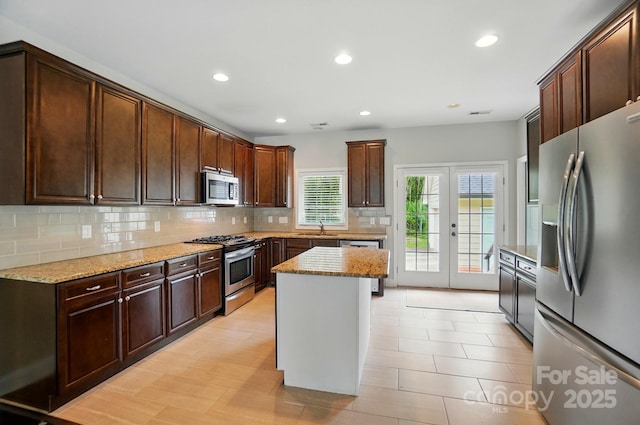 6618 Alexander Rd, Charlotte, NC 28270 - kitchen featuring stainless steel appliances, backsplash, light stone counters, a sink, and recessed lighting