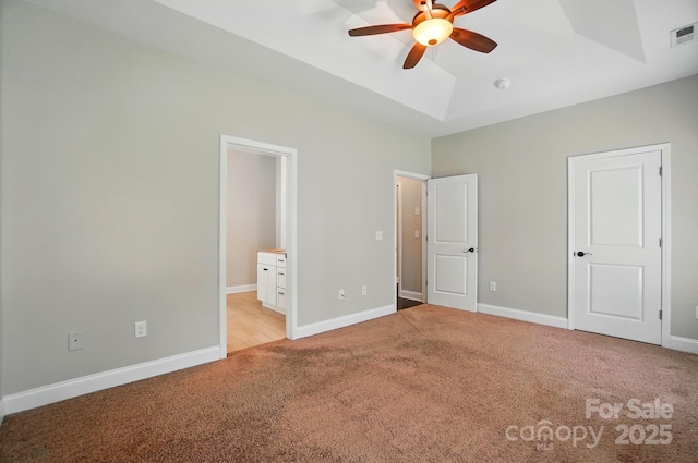 6618 Alexander Rd, Charlotte, NC 28270 - unfurnished bedroom featuring light carpet, a tray ceiling, ensuite bathroom, and baseboards