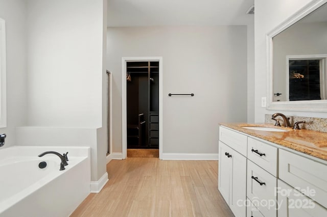6618 Alexander Rd, Charlotte, NC 28270 - full bath with a garden tub, vanity, wood finished floors, a walk in closet, and baseboards