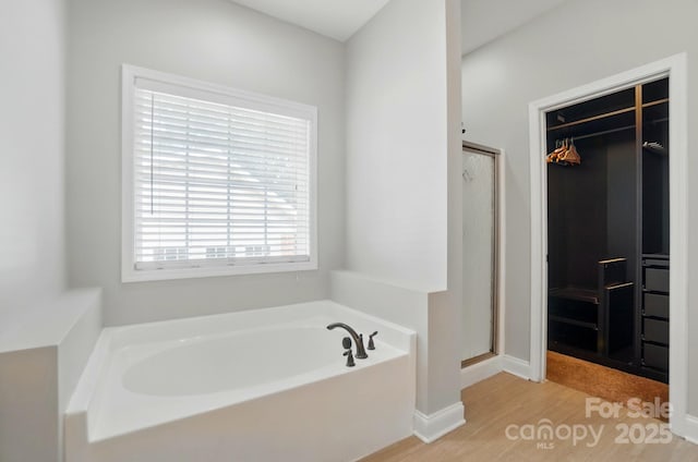 6618 Alexander Rd, Charlotte, NC 28270 - full bathroom featuring a garden tub, wood finished floors, a stall shower, baseboards, and a spacious closet